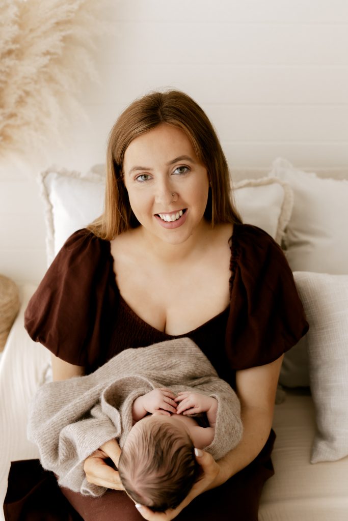 Mum holding baby facing her, looking at the camera
