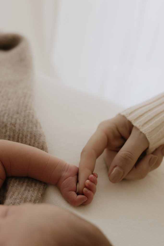 Baby holding mums finger